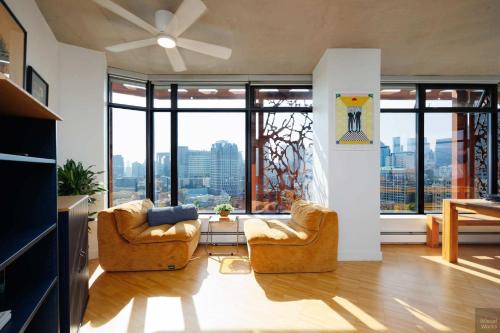 a living room with two chairs and large windows at Spacious 2BD in Vancouver Patio with Ocean View in Vancouver