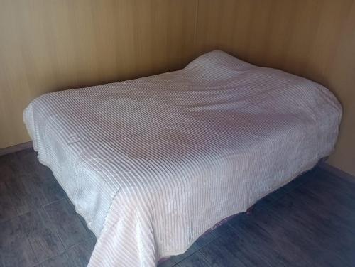 a bed with a white bedspread in a room at Las Casitas de Don Hugo in General Belgrano