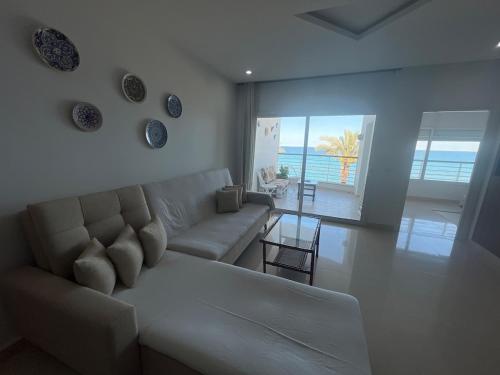 a living room with a couch and a view of the ocean at Mahdia front mer 3 in Hiboun