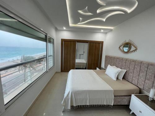 a bedroom with a bed and a view of the ocean at Mahdia front mer 3 in Hiboun