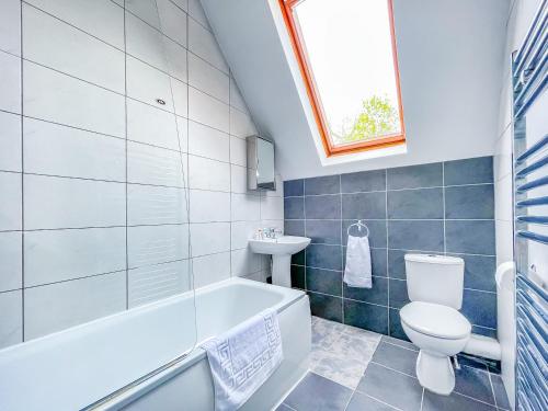 a bathroom with a tub and a toilet and a sink at -RBbc-Cozy Double Room in Shared House in Moortown