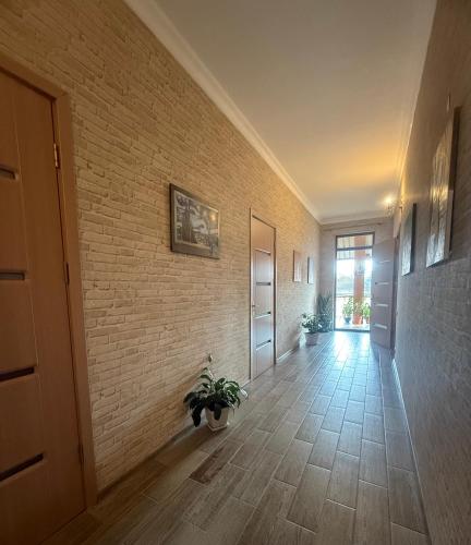 a hallway with a brick wall and a potted plant at nino hotel in K'obulet'i