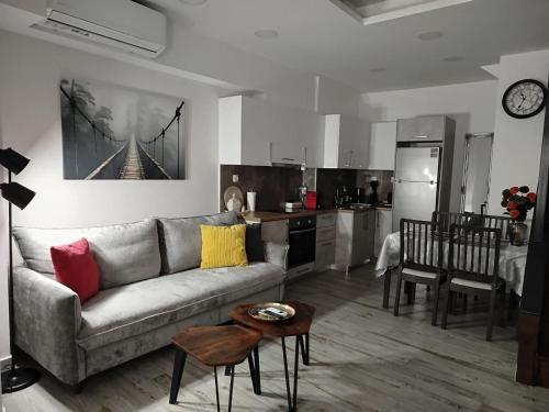 een woonkamer met een bank en een keuken bij THOMAS LUXURY APARTMENT in the historical center of Ioannina in Ioannina
