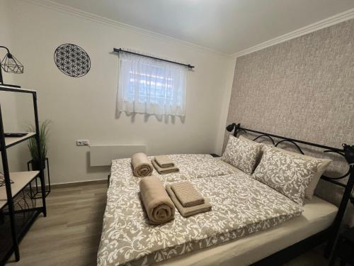 a bedroom with a bed with towels on it at Kincsem Vendégház in Tiszakécske