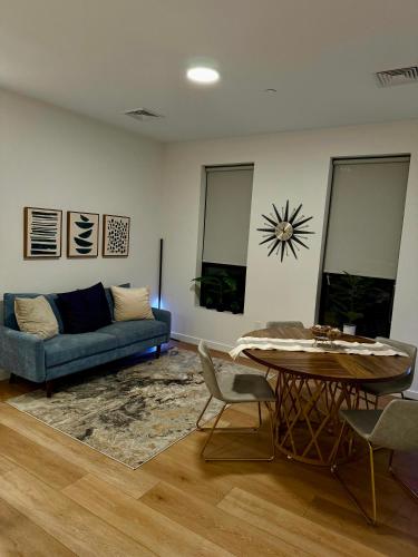 a living room with a blue couch and a table at Modern & Spacious 2BR Apartment with Gym & Parking in New Haven
