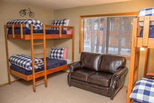 a room with bunk beds and a chair and a couch at Sunriver Vacation House in Sunriver