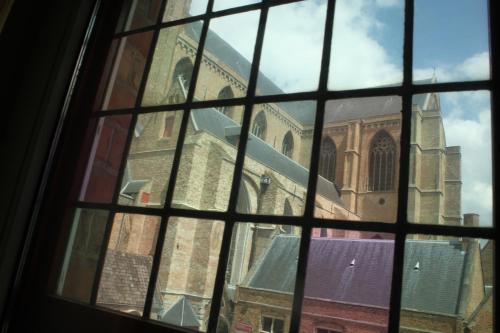a view of a church through a window at Hotel Salvators in Bruges