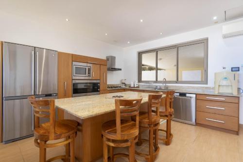 a kitchen with a large island with bar stools at Fare Toamagiti in Paea