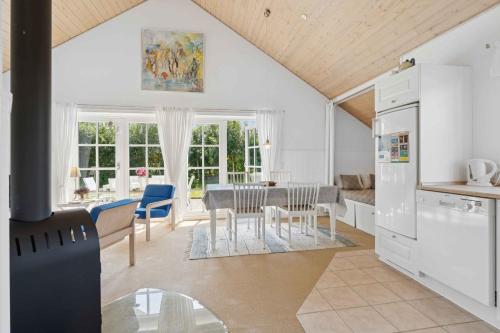 a kitchen and dining room with a table and chairs at Peaceful Cottage In Scenic Surroundings in Højsand