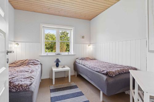 a bedroom with two beds and a window at Peaceful Cottage In Scenic Surroundings in Højsand