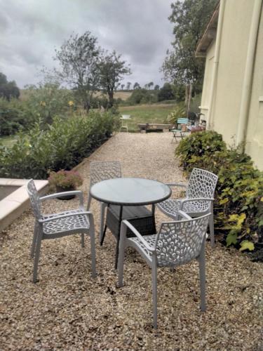 a table and two chairs and a table with a table and chairs at Charming pied-à-terre in Vieux-Ruffec
