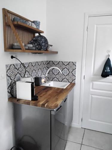 a kitchen with a sink and a counter top at Charming pied-à-terre in Vieux-Ruffec