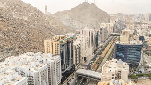 an aerial view of a city with buildings and mountains at Masar Al Aziziyah Hotel in Makkah