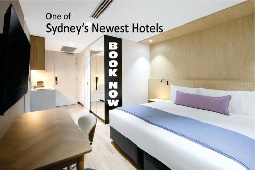 a bedroom with a bed and a tv and a table at Haberfield Hotel in Sydney