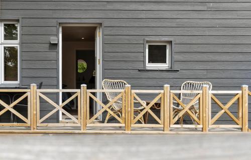 two chairs on a wooden fence in front of a house at 1 Bedroom Beautiful Apartment In Bogense in Bogense