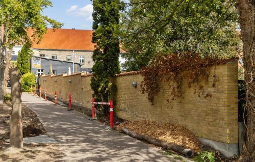 a brick wall next to a sidewalk next to a street at 1 Bedroom Beautiful Apartment In Bogense in Bogense