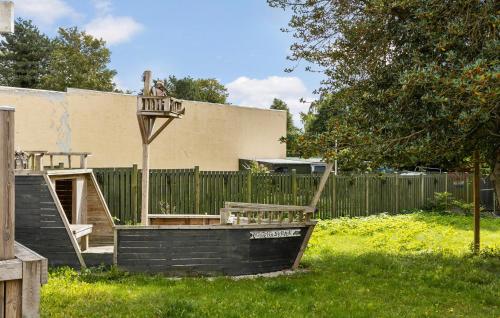 a wooden playground in a yard next to a fence at 1 Bedroom Beautiful Apartment In Bogense in Bogense