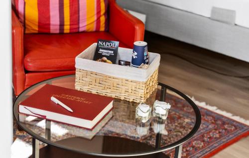 a coffee table with a basket and books and a chair at 1 Bedroom Beautiful Apartment In Bogense in Bogense