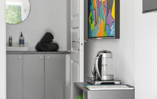 a kitchen with white cabinets and a blender on a counter at 1 Bedroom Beautiful Apartment In Bogense in Bogense