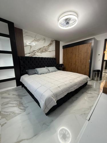 a bedroom with a large bed and marble floors at Incredible Luxury apartment in TGZ Chis in Tuxtla Gutiérrez