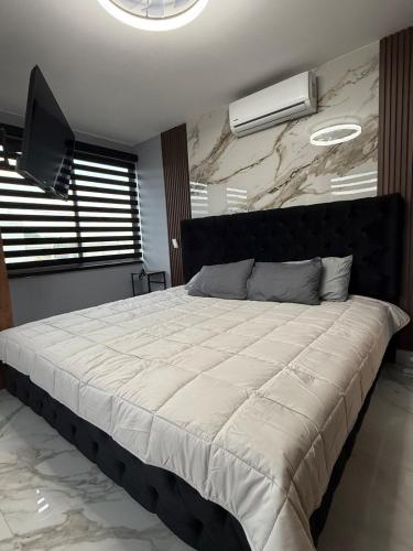 a bedroom with a large bed with a white comforter at Incredible Luxury apartment in TGZ Chis in Tuxtla Gutiérrez