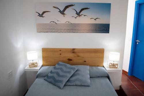a bedroom with a bed with birds flying over the ocean at La Gaviota in Puerto de la Cruz