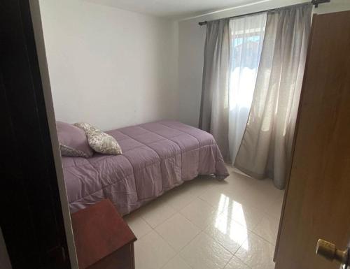 a small bedroom with a bed and a window at Hospedaje la machi in Algarrobo