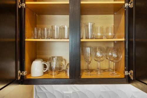 a cupboard filled with glasses and utensils at 2 BR Heart of Frisco Gem in Frisco