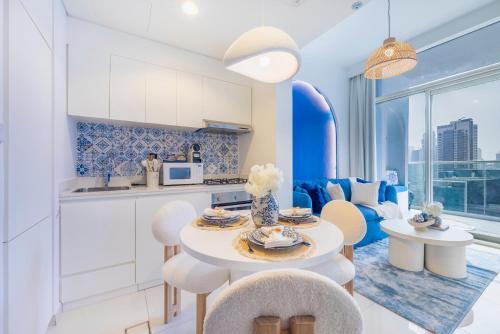 a kitchen and living room with a table and chairs at Luxury Apartment with Balcony & Full Burj Khalifa View by Dejaview Stays in Dubai