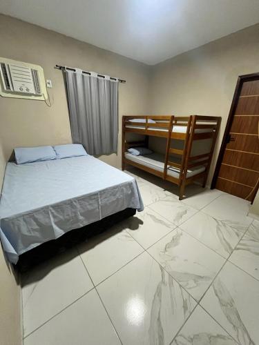 a bedroom with a bed and a tiled floor at Pitimbu Beach House in Pitimbu