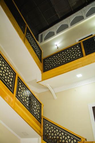 a staircase in a building with wood and metal railing at People Tours Bukhara in Muruntau
