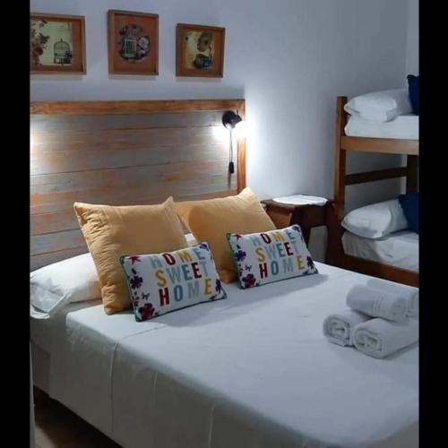 a bedroom with a white bed with two pillows at Complejo Alma Misionera in Puerto Iguazú