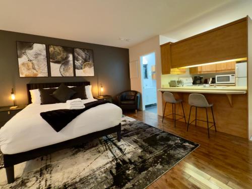 een slaapkamer met een groot bed en een keuken bij Refuge Urbain Quebec - Loft Bonséjours in Québec
