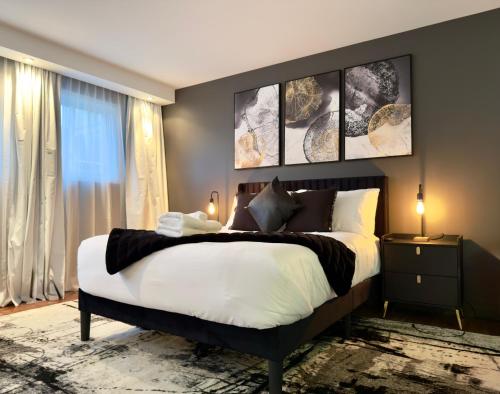 een slaapkamer met een groot bed met vier foto's aan de muur bij Refuge Urbain Quebec - Loft Bonséjours in Québec