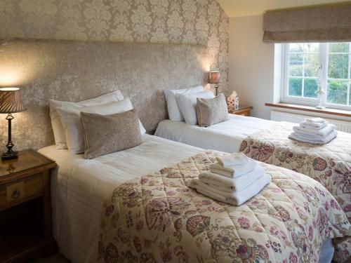 a bedroom with two beds with towels on them at Black A Moor Ripon in Ripon