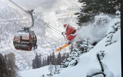 a person on skis jumping off a snow covered mountain at Peaceful Sunny Ski Out Ski In Condo, Parking, Pets in Telluride