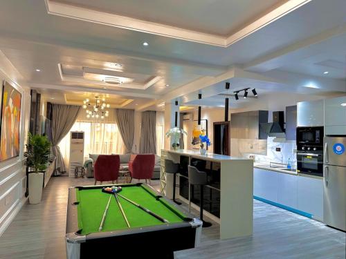 a kitchen with a pool table in a living room at Kirbys Cove in Lekki
