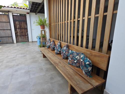 a wooden bench with four pillows on it at Posada Casa Bonita in Puerto Maldonado