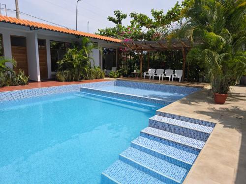 a swimming pool with stairs next to a house at Posada Casa Bonita in Puerto Maldonado