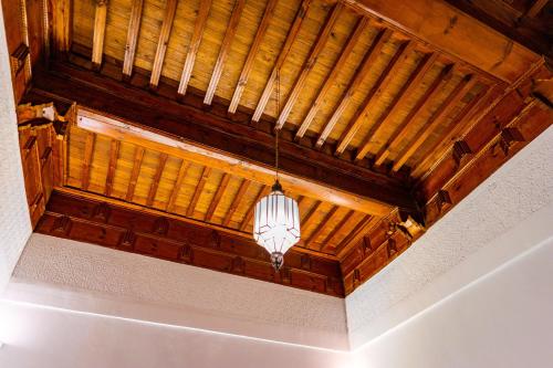 a ceiling with a light hanging from a wooden ceiling at Riad Dar Dialkoum in Marrakech