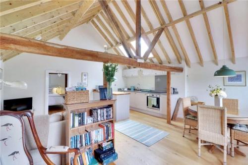 a living room with a table and a dining room at Little Puddingcake - Adorable 1 bedroom guesthouse near Chapel Down in Rolvenden