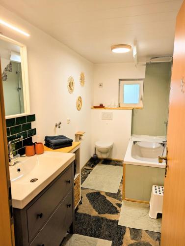 a bathroom with a sink and a toilet and a tub at Ferienhaus Eifelheide in Kall