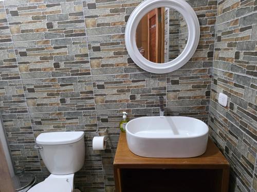 a bathroom with a white sink and a mirror at Posada Casa Bonita in Puerto Maldonado