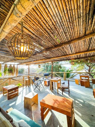 a pavilion with tables and benches and a chandelier at Villa Naylamp loft en las pocitas in Máncora