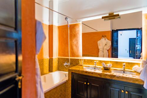 a bathroom with a sink and a large mirror at Riad Dar Dialkoum in Marrakech