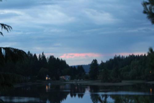 a lake with a house in the middle of a forest at Oyster Bay Inn & Suites in Bremerton