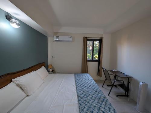 a bedroom with a bed and a desk and a window at Sunset Vista homely apartment in Méro