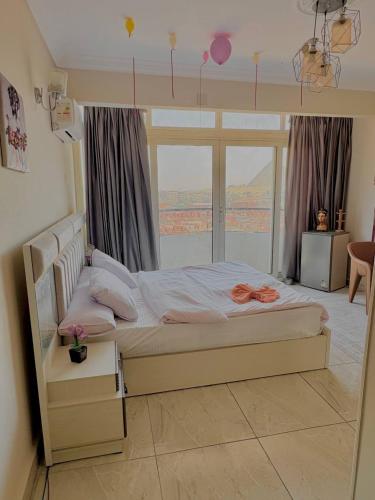 a bed in a room with a large window at Giza pyramids view & jacuzii in Cairo
