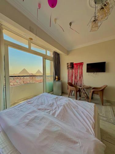 a bedroom with a bed and a large window at Giza pyramids view & jacuzii in Cairo