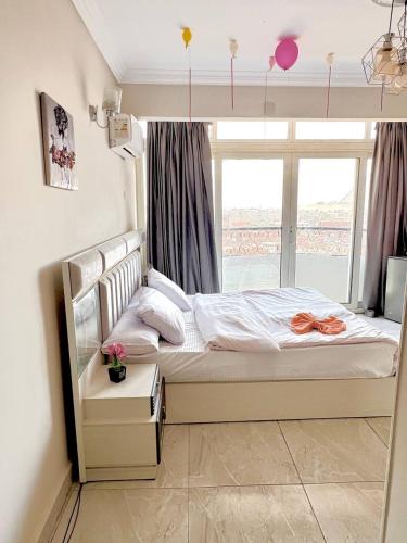 a bed in a room with a large window at Giza pyramids view & jacuzii in Cairo